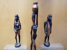 Three wooden African tribal carvings comprising a pair depicting a male and a female figure