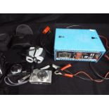 An ABSAAR 12v, 11 amp battery charger, cameras and a pair of 10 x 25 binoculars.