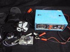 An ABSAAR 12v, 11 amp battery charger, cameras and a pair of 10 x 25 binoculars.