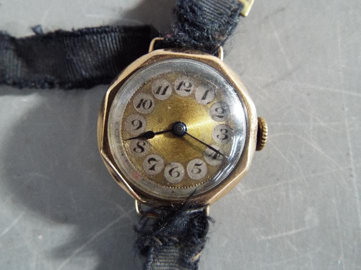 A 9 ct gold cased lady's wristwatch, stamped 9 and .375, on fabric strap, approximately 14. - Image 2 of 2