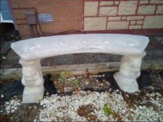 A reconstituted stone garden bench decorated with squirrel supports