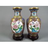 A pair of Chinese cloisonné enamel vases decorated to each side with panels of flowers and birds on