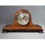 A mahogany and inlaid case Napoleons hat style mantel clock, silvered dial with Arabic numerals,