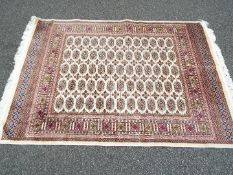 A Bokhara carpet on a beige ground measuring 190 cm x 133 cm, (nominal use,