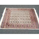 A Bokhara carpet on a beige ground measuring 190 cm x 133 cm, (nominal use,