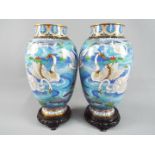 A pair of Chinese cloisonné vases decorated with flowers and swimming swans,