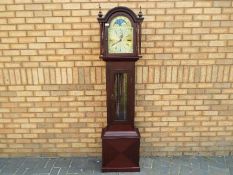 A contemporary dark wood cased grandmother clock with Westminster chiming weight driven movement