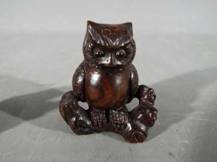 A vintage Japanese dark wood Netsuke depicting an Owl seated on a thick branch or log, - Image 2 of 5