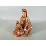 A 19th Chinese soapstone carving depicting Guanyin dressed in flowing robes and holding a scroll,