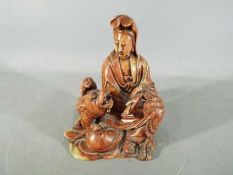 A 19th Chinese soapstone carving depicting Guanyin dressed in flowing robes and holding a scroll,