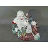 A rare Chinese famille rose laughing Buddha holding prayer beads, with two attendants,