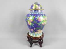 A large Chinese cloisonné enamel vase and cover decorated with branches of peach,