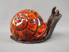 An Anita Harris model depicting a snail, approximately 14 cm (h), 25 cm (l).