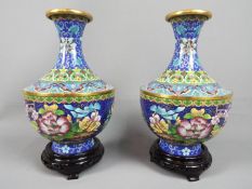 A pair of Chinese cloisonné vases decorated with auspicious flowers, scrolling lotus to the neck,