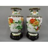 A pair of Chinese cloisonné vases decorated with flowers, birds and insects on a white ground,
