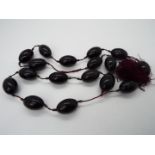 A strand of 17 cherry amber beads, each oval shaped bead approximately 30 mm x 19 mm,