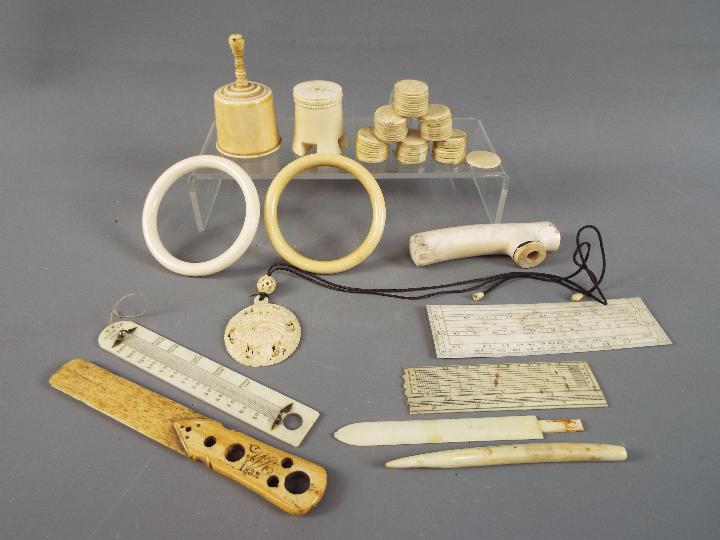 A collection of 19 th and early 20 th century worked ivory to include gaming tokens, bracelets,