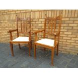 A pair of oak high back chairs with upholstered seats and arm rests