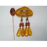 An amber brooch with four drop pendants and a hatpin, 38 grams all in.