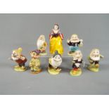 Beswick - A set of Beswick Snow White and the Seven Dwarfs figurines with gold back stamp,
