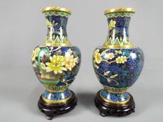 A pair of Chinese cloisonné vases of baluster form decorated with auspicious flowers against a