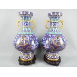 A large pair of twin handled Chinese cloisonné vases on raised foot,