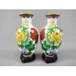 A pair of Chinese cloisonné vases decorated with flowers and birds on a white ground,