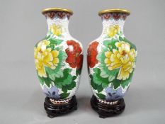 A pair of Chinese cloisonné vases decorated with flowers and birds on a white ground,