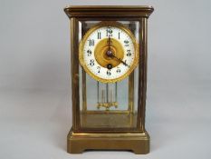 A timepiece only, four-glass and brass mantel clock, the dial having enamel chapter ring,