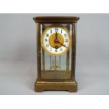 A timepiece only, four-glass and brass mantel clock, the dial having enamel chapter ring,