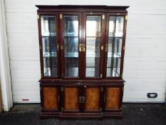 A large Chinese display cabinet with carved walnut panels, brass detailing with two keys,