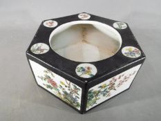 A Chinese hexagonal form famille rose jardiniere, decorated with panels depicting flowers and birds,