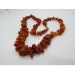 A graduated amber bead necklace of graduated amber chips, largest approximately 20 mm x 8 mm,