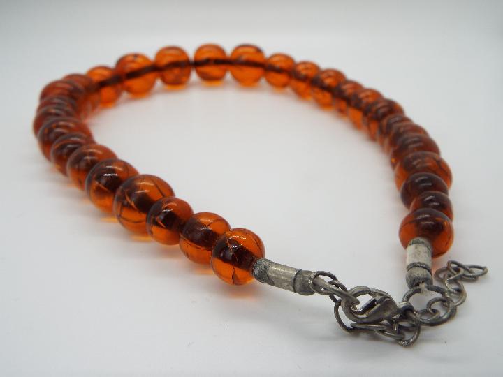 A graduated amber bead necklace of 30 beads, largest approximately 24 mm x 22 mm, - Image 3 of 4
