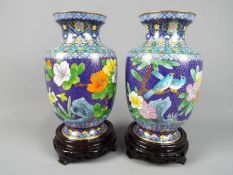 A pair of Chinese cloisonné vases decorated to the body with flowers and birds against a blue