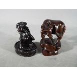 A vintage Japanese dark wood Netsuke depicting a lady bathing,