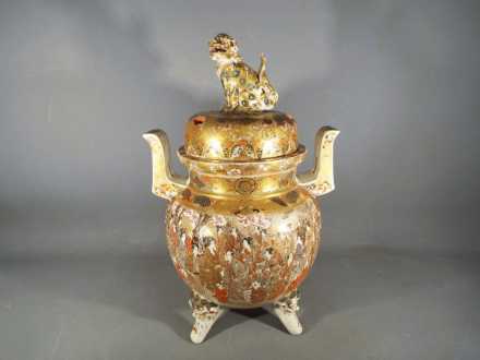 A large Meiji period Satsuma koro and cover of oviform with twin pierced handles and raised on