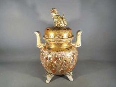 A large Meiji period Satsuma koro and cover of oviform with twin pierced handles and raised on