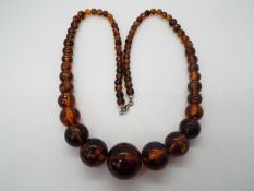 A graduated amber bead necklace, largest approximately 25 mm (d), smallest 7 mm,