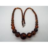 A graduated amber bead necklace, largest approximately 25 mm (d), smallest 7 mm,