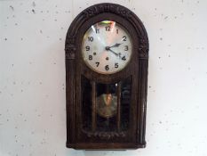 An Art Deco styled arched top dark oak wall clock by the German maker HAC,