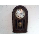 An Art Deco styled arched top dark oak wall clock by the German maker HAC,