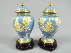 A pair of Chinese Zi Jin Cheng cloisonné vases with covers decorated with peony against a blue