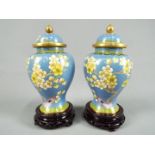 A pair of Chinese Zi Jin Cheng cloisonné vases with covers decorated with peony against a blue