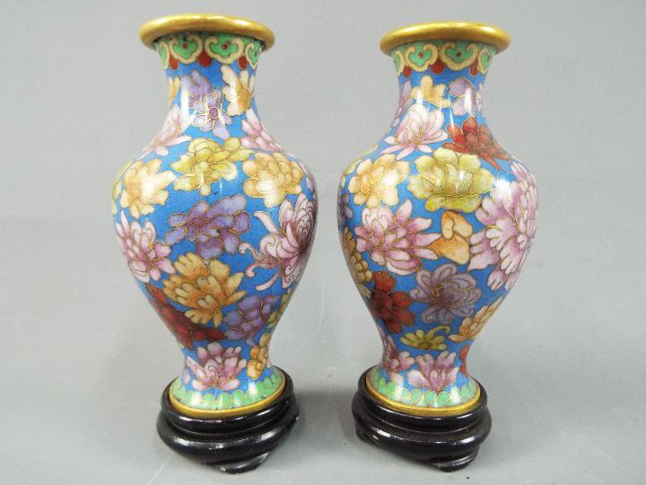 A small pair of Chinese cloisonné vases decorated with chrysanthemum on a blue ground,