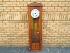 An early 20th century regulator wall clock signed to the 10 inch white enamel dial for JG Baer,