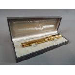 A boxed Dunhill fountain pen with 14 ct gold nib.