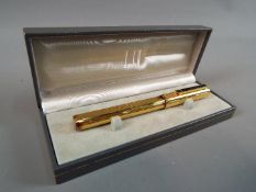 A boxed Dunhill fountain pen with 14 ct gold nib.