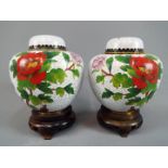 A pair of Chinese cloisonné ginger jars and covers decorated with flowers and butterfly,