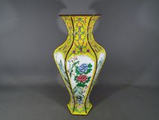 A Chinese early 20th century Canton enamel vase of hexagonal and baluster form with flaring neck,